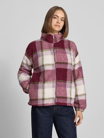 Frauenmodel trägt Regular Fit Jacke aus Teddyfell Modell 'Luca' von NOISY MAY®, kariertes Design in Rosa, Weiß und Olive, Nahaufnahme Oberkörper.