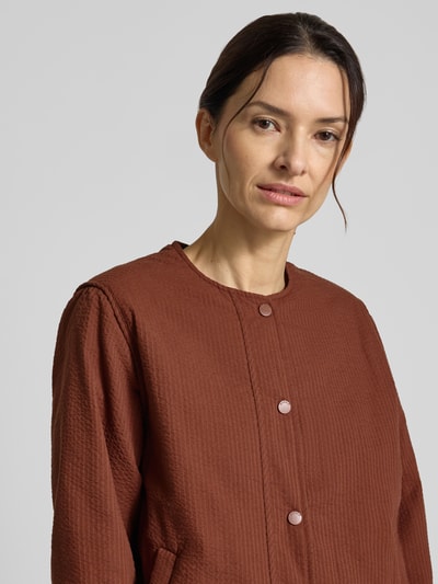 Frauenmodel trägt Jacke mit Rundhalsausschnitt Modell 'GABI' von ECOALF in Braun, reine Baumwolle, Knopfleiste, Nahaufnahme Oberkörper.