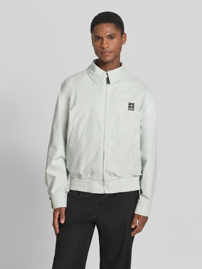 Männermodel trägt Regular Fit Blouson mit Logo-Detail Modell 'Bartos' von HUGO in Optik: Allover-Muster, Eingrifftaschen, Reißverschluss, Hellgrau, Struktur glatt, Ganzkörperansicht von vorne.