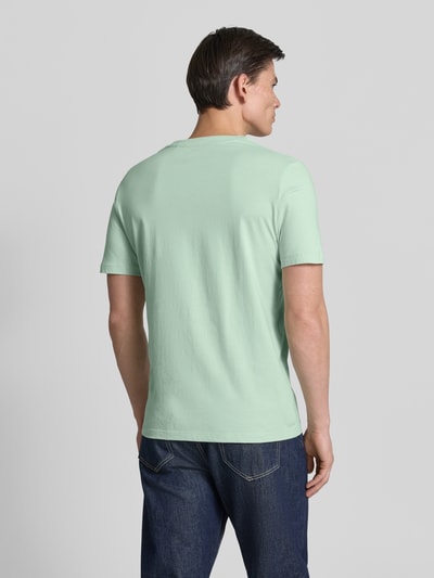 Männermodel trägt Regular Fit T-Shirt aus reiner Baumwolle von s.Oliver RED LABEL in Optik: Unifarben, Jersey-Textur, Ganzkörperansicht Rückansicht.