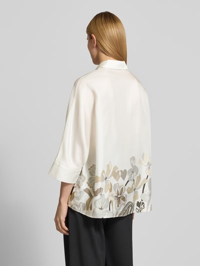 Frauenmodel trägt Relaxed Fit Hemdbluse aus reiner Seide mit floralem Print von HERZENS, florales Muster, 3/4-Arm, Rückenansicht, Ganzkörperansicht Rückansicht. Rückenlänge 73 cm, Ärmellänge 43 cm, durchgängige Knopfleiste, helle und neutrale Farbtöne, weiche, glatte Seidenstruktur.