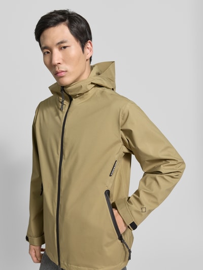 Männermodel trägt Jacke mit Kapuze und Reißverschlusstaschen Modell 'CYCLONE' von GOFRANCK in Beige, Reine Baumwolle, Gerader-Schnitt, Label-Detail, verstellbare Ärmelriegel mit Klettverschluss, Rückenlänge 71 cm, Schulterbreite 48 cm, Brustweite 49 cm, Ärmellänge 65 cm, Ganzkörperansicht von vorne.