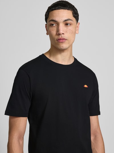 Männermodel trägt T-Shirt mit Label-Stitching Modell 'CASSICA' von Ellesse, reine Baumwolle, gerader Schnitt, Nahaufnahme Oberkörper.