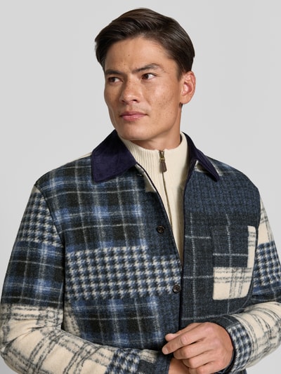 Männermodel trägt Regular Fit Hemdjacke mit Eingrifftaschen von MCNEAL im karierten Muster, beige-blau, Nahaufnahme Oberkörper. Herren Hemdjacke, Umlegekragen, durchgehende Knopfleiste, umgeschlagene Ärmelabschlüsse, Rückenlänge 73 cm bei Größe M.
