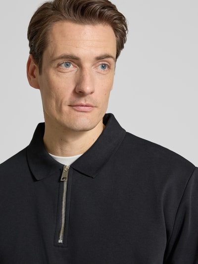 Männermodel trägt Sweatshirt mit Polokragen und Reißverschluss von Lindbergh, schwarzer Baumwoll-Mix, Regular-Fit, Nahaufnahme Oberkörper.
