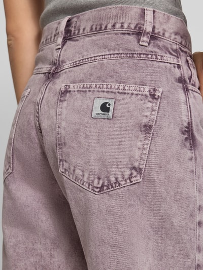 Frauenmodel trägt Straight Fit Jeansshorts im 5-Pocket-Design von Carhartt Work In Progress aus Reine Baumwolle, Bundweite 40 cm, Innenbeinlänge 26 cm, lila Batik-Optik, Nahaufnahme Rückansicht.