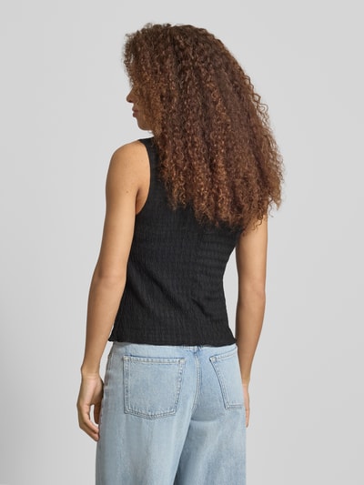 Frauenmodel trägt Slim Fit Weste mit Seersucker-Struktur Modell 'ILSE' von Only in Schwarz, einfarbig mit Rundhals, Ganzkörperansicht Rückansicht.