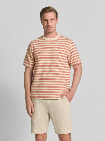 Männermodel trägt Regular Fit T-Shirt aus Baumwoll-Mix Modell 'ELI' von Selected Homme mit roten Streifen und Struktur, Ganzkörperansicht von vorne. Herren T-Shirt.