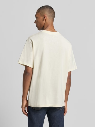 Männermodel trägt Relaxed Fit T-Shirt aus reiner Baumwolle Modell 'MAARKOS' von ARMEDANGELS in Creme, glatte Oberfläche, Ganzkörperansicht Rückansicht.