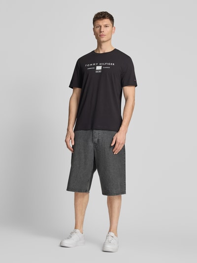 Männermodel trägt Regular Fit T-Shirt aus reiner Baumwolle von Tommy Hilfiger, Optik: Unifarben, Label-Print, Rundhals, Kurzarm, Ganzkörperansicht von vorne.
