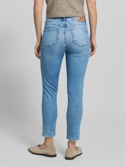 Frauenmodel trägt Slim Fit Jeans mit Strasssteinbesatz Modell 'Ornella Beauty' von Angels, hellblauer Baumwoll-Mix, 5-Pocket-Design, Ganzkörperansicht Rückansicht.