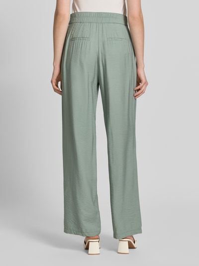 Frauenmodel trägt Wide Fit Chino aus Viskose-Mix mit Gesäßtaschen von Betty Barclay in zartem Grün, strukturierte Oberfläche, Ganzkörperansicht Rückansicht. Bundweite bei Größe 36: 36 cm, Innenbeinlänge: 80 cm, Haken- und Reißverschluss.