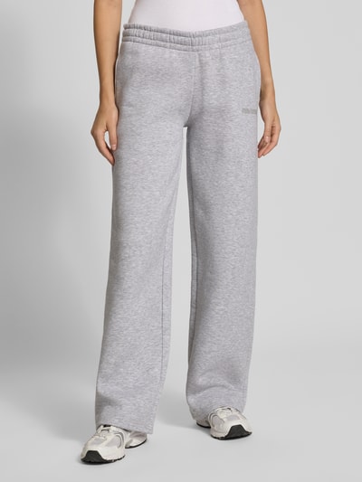 Frauenmodel trägt Sweathose in grau melange mit geradem Bein von REVIEW, Baumwoll-Mix, elastischer Bund, Ganzkörperansicht von vorne.