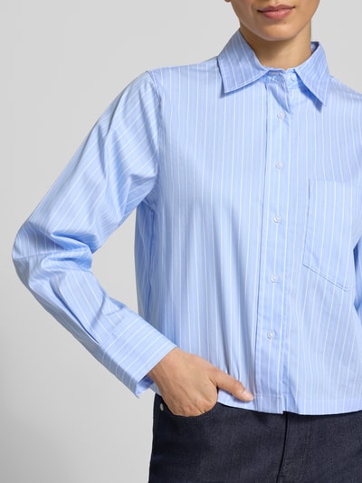 Frauenmodel trägt Boxy Fit Hemdbluse aus Baumwoll-Mix von s.Oliver BLACK LABEL, Optik:Allover-Muster, Passform:Boxy-Fit, Hemdblusenkragen, Länge:Cropped, einreihige Knopfleiste, Langarm mit Manschette, Brusttasche, Material:Baumwoll-Mix, Hellblau mit weißen Streifen, glatte Struktur, Nahaufnahme Oberkörper.