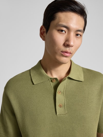 Männermodel trägt Relaxed Fit Poloshirt aus reiner Baumwolle Modell 'DANE' von SELECTED HOMME, Optik: Unifarben, Strickoptik, Nahaufnahme Oberkörper.