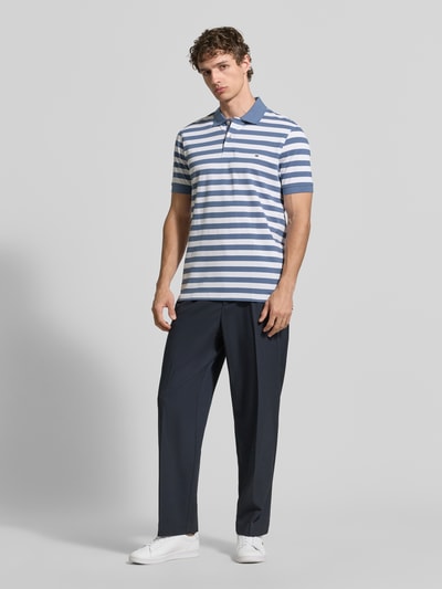 Männermodel trägt Modern Fit Poloshirt mit Logo-Stitching von Christian Berg Men, blau-weiß gestreift, reine Baumwolle, Ganzkörperansicht von vorne.