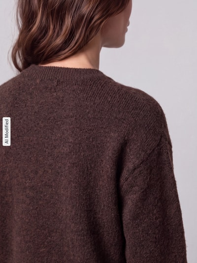 Frauenmodel trägt Regular Fit Pullover mit Woll-Anteil Modell 'ALLY' von PIECES in Dunkelbraun mit weicher Textur, Ganzkörperansicht Rückansicht, KI-modifiziertes Bild.