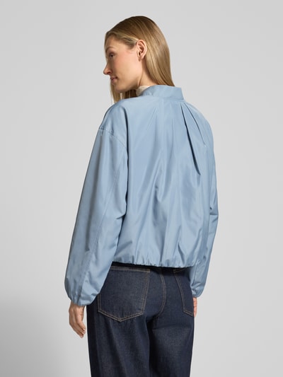 Kobiece modelka nosi Jacke mit Reißverschlusstaschen von Fuchs Schmitt, krój regular fit, stójka, detal z zamkiem błyskawicznym, kieszenie zapinane na zamek błyskawiczny, długość tyłu w rozmiarze 36: 52 cm, szerokość ramion w rozmiarze 36: 54 cm, szerokość klatki piersiowej w rozmiarze 36: 57 cm, długość rękawów w rozmiarze 36: 53 cm, jasnoniebieski, gładka tekstura, całkowity widok z tyłu.