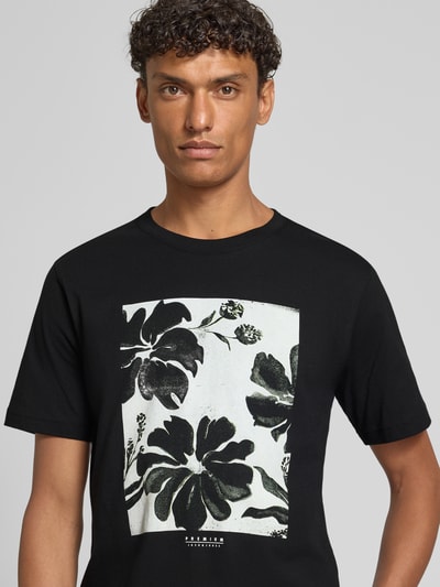 Männermodel trägt T-Shirt mit Motiv-Print Modell 'LUCAS' von Jack & Jones Premium, schwarz, Baumwolle, Nahaufnahme Oberkörper.