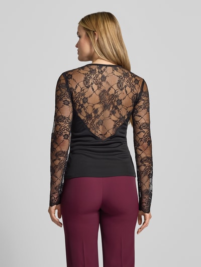 Frauenmodel trägt Slim Fit Longsleeve mit Spitzenbesatz von Rinascimento, półprzezroczysty materiał, lejący kołnierz, długość tyłu w rozmiarze S: 60 cm, czarna i bordowa kolorystyka, obszycie koronką, krój slim fit, Ganzkörperansicht Rückansicht.