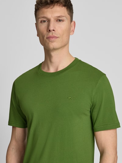Männermodel trägt Regular Fit T-Shirt mit Logo-Stitching von Scotch & Soda in Grün, Reine Baumwolle, Rundhalsausschnitt, Nahaufnahme Oberkörper.