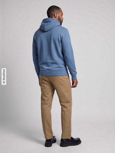 Männermodel trägt Regular Fit Hoodie aus Baumwoll-Mix von GANT in Blau und beigefarbene Hose, Ganzkörperansicht Rückansicht, KI-modifiziertes Bild.