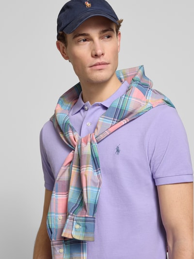 Męski model nosi Slim Fit Koszulkę polo z czystej bawełny od Polo Ralph Lauren, efekt: jednolity kolor, kołnierzyk polo, aplikacja z wyhaftowanym logo, detal z logo, zapięcie na krótką listwę guzikową, krótki rękaw z prążkowanym wykończeniem, boczne rozcięcia z asymetrią, wykończenie materiału: pika, materiał: czysta bawełna, całkowite ujęcie górnej części ciała z przodu.
