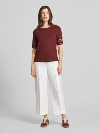 Vrouwenmodel draagt Regular Fit T-Shirt uit zuivere katoen model 'IVACY' van Vero Moda, effen, met opengewerkte borduursel, ronde hals, korte mouw, vooraanzicht hele lichaam.