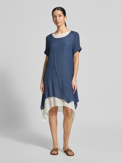 Frauenmodel trägt Knielanges Kleid aus Viskose-Mix von Apricot in Blau mit Rundhalsausschnitt, asymmetrischem Saum und lockerer Passform, Ganzkörperansicht von vorne.