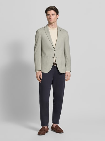 Männermodel trägt Modern Fit 2-Knopf-Sakko mit Reverskragen von Pierre Cardin, Baumwoll-Mix mit Stretch-Anteil, Eingrifftaschen, Label-Detail, hellgrau, kombiniert mit dunkler Hose, Ganzkörperansicht von vorne.