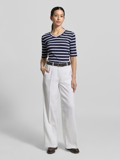 Kobiece modelka ma na sobie T-shirt mit Streifenmuster und V-Ausschnitt von Christian Berg Woman, mieszanka bawełny i elastanu, krój regular fit, wzór w paski, dekolt w serek, długość tyłu w rozmiarze S: 55 cm, widok całej sylwetki z przodu.