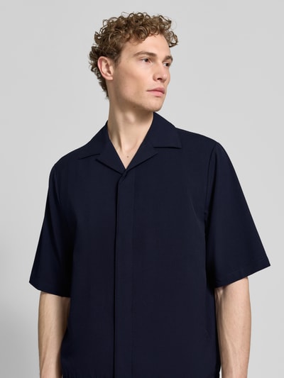 Mężczyzna nosi Relaxed Fit Hemdjacke mit Reverskragen od Lindbergh z mieszanki materiałów z wiskozą, kolor ciemnogranatowy, zakryta listwa guzikowa, szerokość w rozmiarze M: 48 cm, długość pleców: 69 cm, długość rękawa: 34 cm, prosty fason, gładka tekstura, nahaufnahme górnej części ciała.
