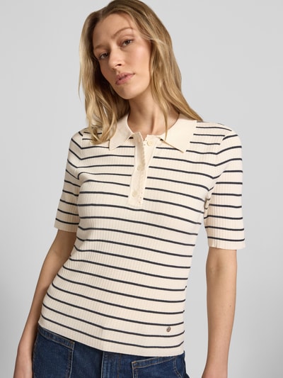Frauenmodel trägt Strickshirt mit Streifenmuster Modell 'Caliz' von MOS MOSH aus Viskose-Mix mit Seiden-Anteil, Ripp-Optik, Polokragen, Knopfleiste, Regular-Fit, Rückenlänge 54 cm, Ärmellänge 26 cm, Ganzkörperansicht von vorne.