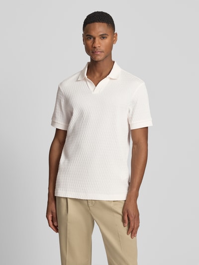 Männermodel trägt Regular Fit Poloshirt mit V-Ausschnitt Modell 'Rauljose' von JOOP! Collection aus reiner Baumwolle mit Strukturmuster, Ganzkörperansicht von vorne.