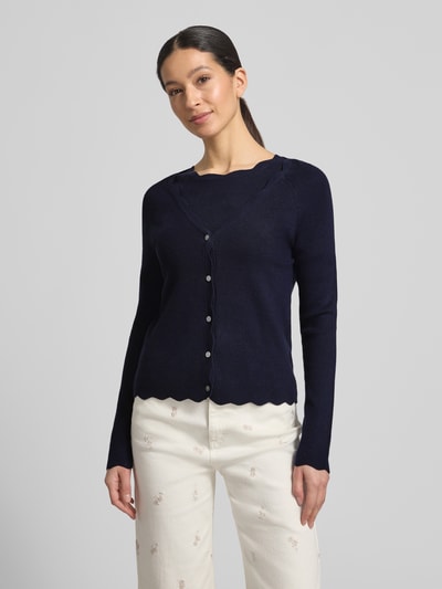 Frauenmodel trägt Strickcardigan aus Viskose-Mix von Christian Berg Woman in Dunkelblau mit Rüschen, Knopfleiste, tailliertem Schnitt, Nahaufnahme Oberkörper.