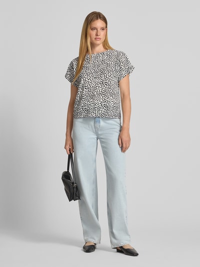 Frauenmodel trägt Blusenshirt im Allover-Look Modell 'JOSA' von Vila mit Rundhalsausschnitt, Schwarz-Weiß-Muster, Ganzkörperansicht von vorne.