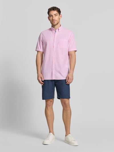 Männermodel trägt Regular Fit Freizeithemd mit Brusttasche von Christian Berg Men aus Reine Baumwolle, rosa-weiß gestreift, Ganzkörperansicht von vorne.