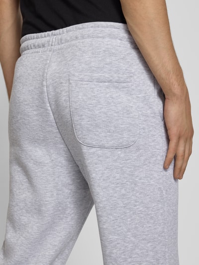 Männermodel trägt Regular fit sweatpants mit steekzakken Modell 'GORDON' van JACK & JONES in lichtgrijs Materiaalmix, detailaufnahme achterzak