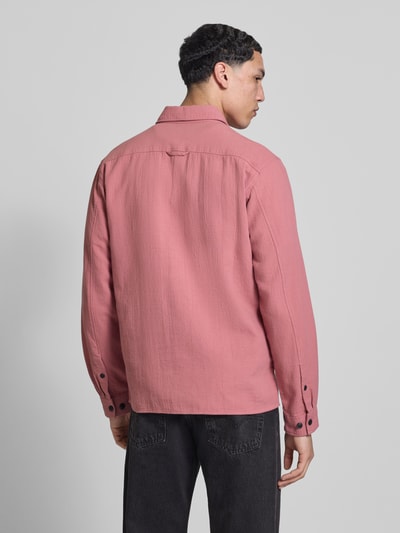 Männermodel trägt Regular Fit Freizeithemd aus reiner Baumwolle von Marc O'Polo Denim in Rosa mit Struktur, Rückenpasse, Ganzkörperansicht Rückansicht.