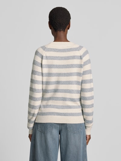 Frauenmodel trägt Regular Fit Pullover mit Streifen Modell 'DOFFY' von VERO MODA in Creme und Hellblau, grobe Stricktextur, Ganzkörperansicht Rückansicht. Damen Pullover von VERO MODA.