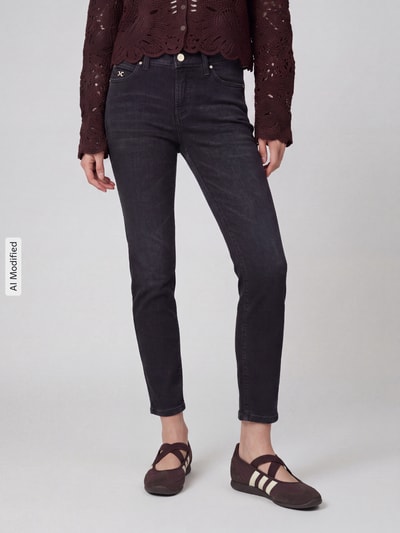 Kobiece modelka nosi czarne jeansy Slim Fit Jeans aus Baumwoll-Mix Modell 'PIPER SHORT' od CAMBIO, ciemny materiał, gładka faktura, Ganzkörperansicht von vorne, jeansy damskie marki CAMBIO, KI-modifiziertes Bild.