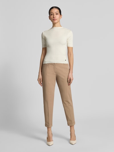 Frauenmodel trägt Chino aus Techno Cotton Superstretch Modell 'UTE' von Raffaello Rossi, Elastischer-Material-Mix, Straight, Verkürzt, Bügelfalten, Eingriffstaschen, Knopf-Reißverschluss, Gürtelschlaufen, Bundweite 40 cm, Innenbeinlänge 68 cm, Ganzkörperansicht von vorne.