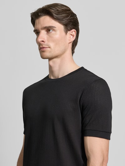 Mannelijk model draagt T-shirt met Rundhalsausschnitt van Antony Morato, regular fit, zwart structuurpatroon, pure katoen, borst detailopname