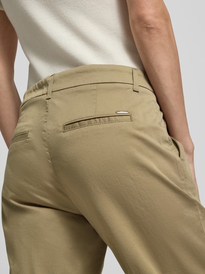 Vrouwenmodel draagt Hose in verkürzter Passform Modell 'MARON' van Brax, beige katoenmix met lyocell, steekzakken, detailopname rug.