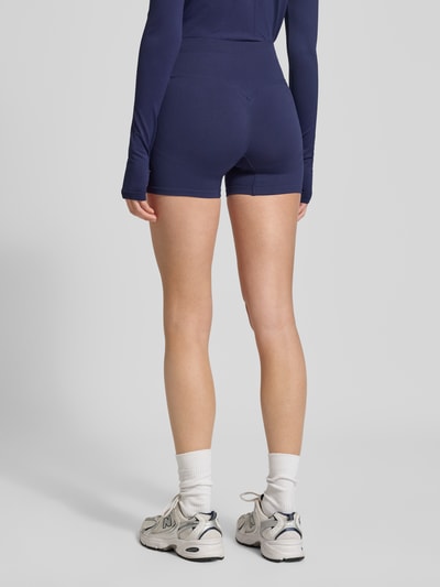 Frauenmodel trägt Slim Fit Shorts mit breitem Bund Modell 'Scrunch' von Fabletics aus Elastischer-Material-Mix, dunkelblau, Ganzkörperansicht Rückansicht. Damen Shorts, Bundweite 31 cm, Innenbeinlänge 10 cm, Größe S.