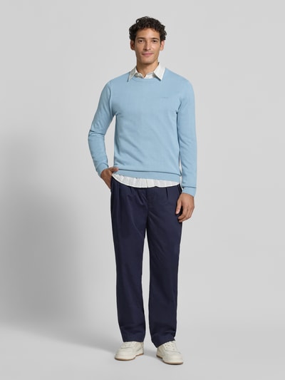 Männermodel trägt Regular Fit Pullover aus reiner Baumwolle von s.Oliver RED LABEL in Hellblau, glatte Struktur, Ganzkörperansicht von vorne.