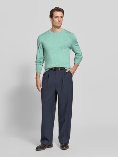 Männermodel trägt Strickpullover mit geripptem Rundhalsausschnitt von MCNEAL in Mint, marineblaue Hose, Ganzkörperansicht von vorne, taillierte Passform, gerippte Abschlüsse, überschnittene Schultern, Rückenlänge 70 cm, Ärmellänge 65 cm.