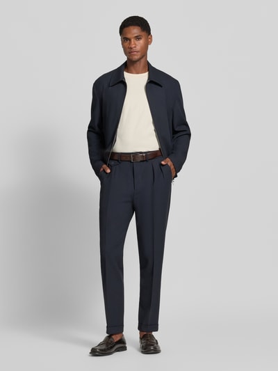 Mannenmodel draagt Slim Fit Hose met Viskose-Anteil van Manuel Ritz in donkerblauw Materiaalmix met bandplooien, zij- en achterzakken, knoop- en ritssluiting, motiefhanger in metallic met karabijnsluiting, bandwijdte 38 cm, binnenbeenlengte 76 cm, Ganzkörperansicht van voren.