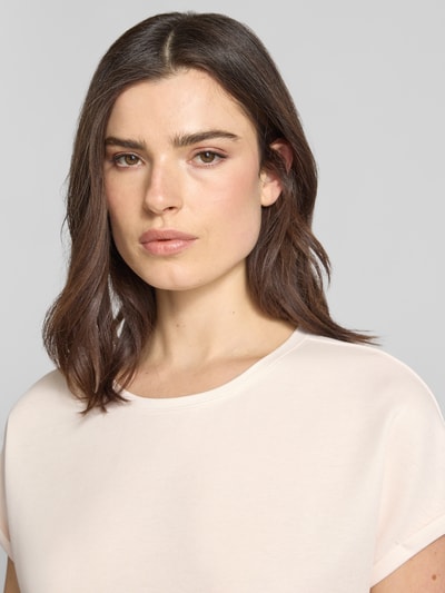 Frauenmodel trägt T-Shirt mit Viskosen-Anteil von Christian Berg Woman, sanfte Cremefarbe, Rundhalsausschnitt, Viskose-Mix, Nahaufnahme Oberkörper.
