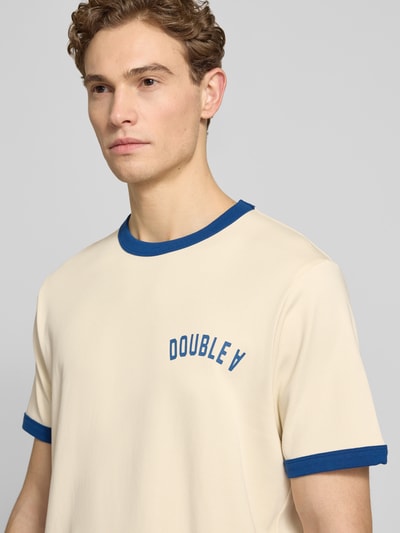 Męski model nosi T-Shirt mit Rundhalsausschnitt od Wood Wood z bawełny, krój regular fit, paski w kontrastowym kolorze, model 'Parker', kolor kremowy i niebieski, długość tyłu w rozmiarze M: 71 cm, półzbliżenie przód.